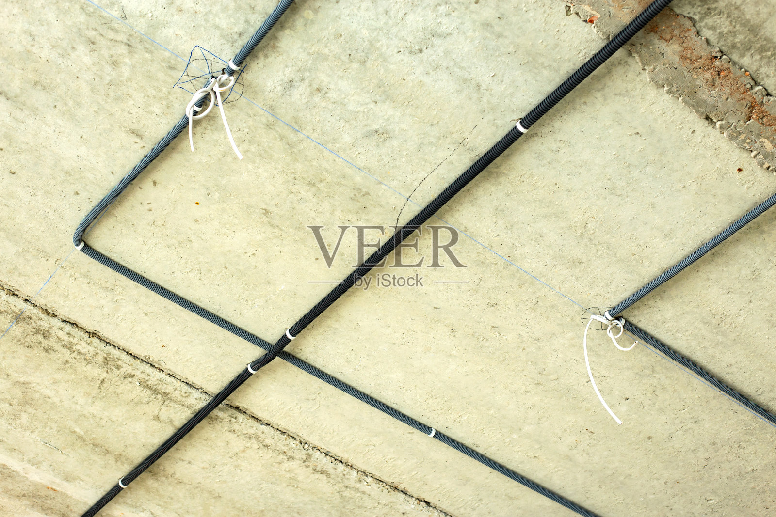 在一间正在施工的房间内，在天花板和墙壁上安装以保护波纹敷设的电缆。照片摄影图片