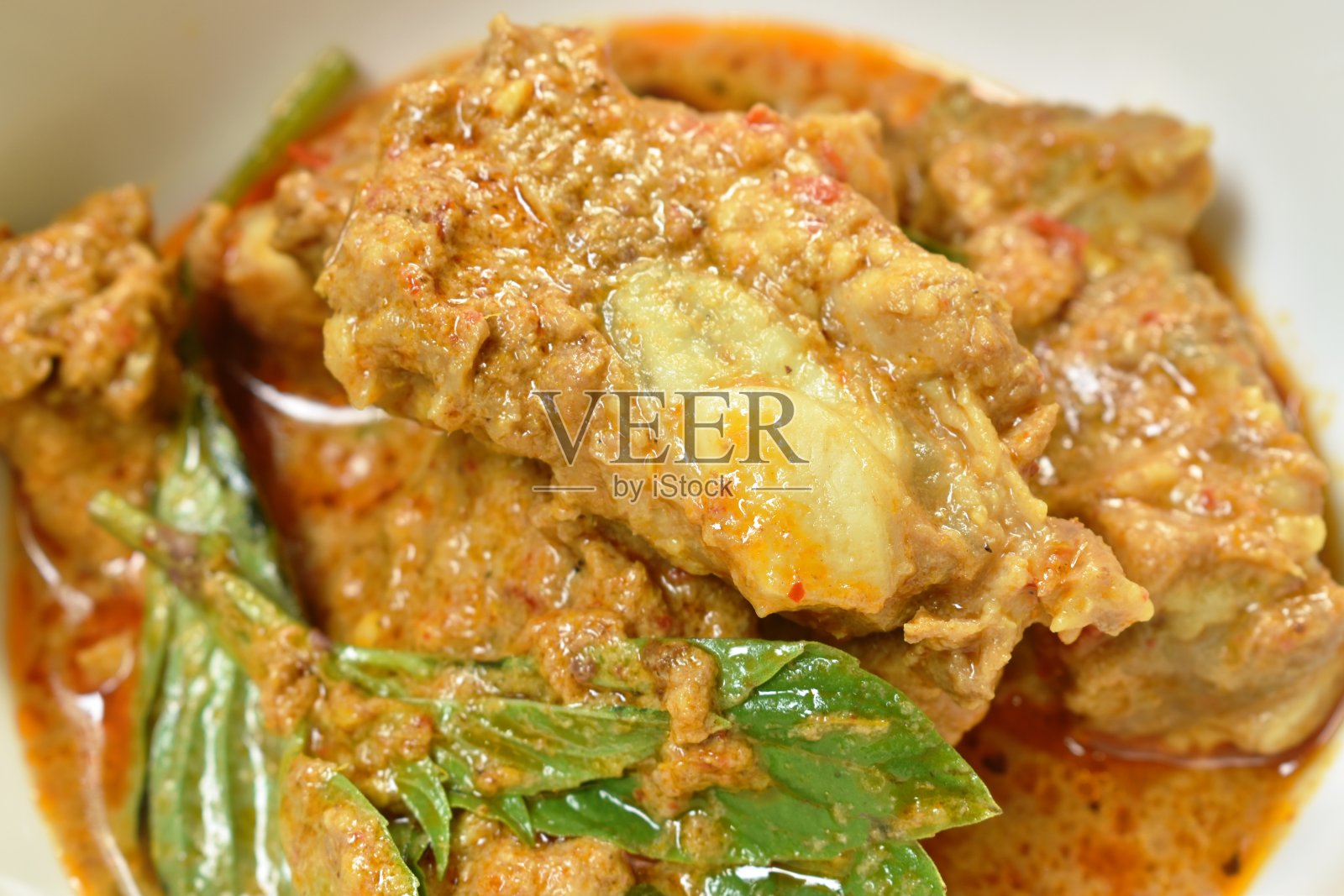 麻辣炒猪骨配香草和咖喱在碗里吃一对蔬菜照片摄影图片