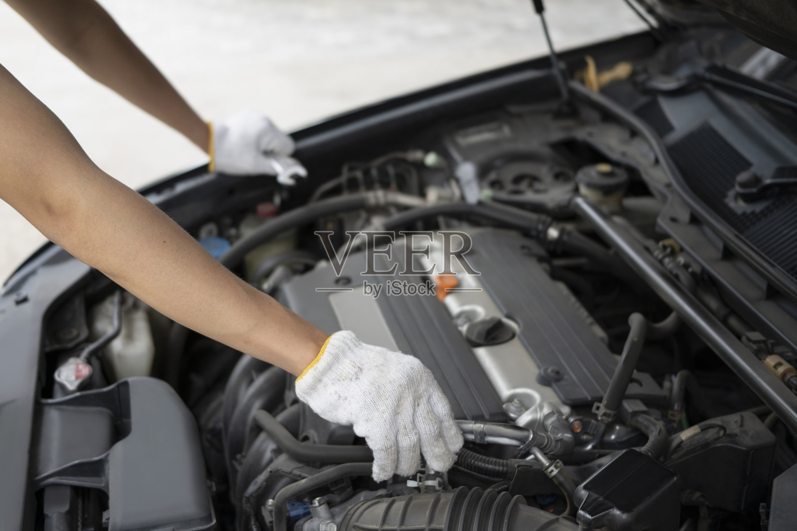 技工正在车库里修理汽车引擎。照片摄影图片