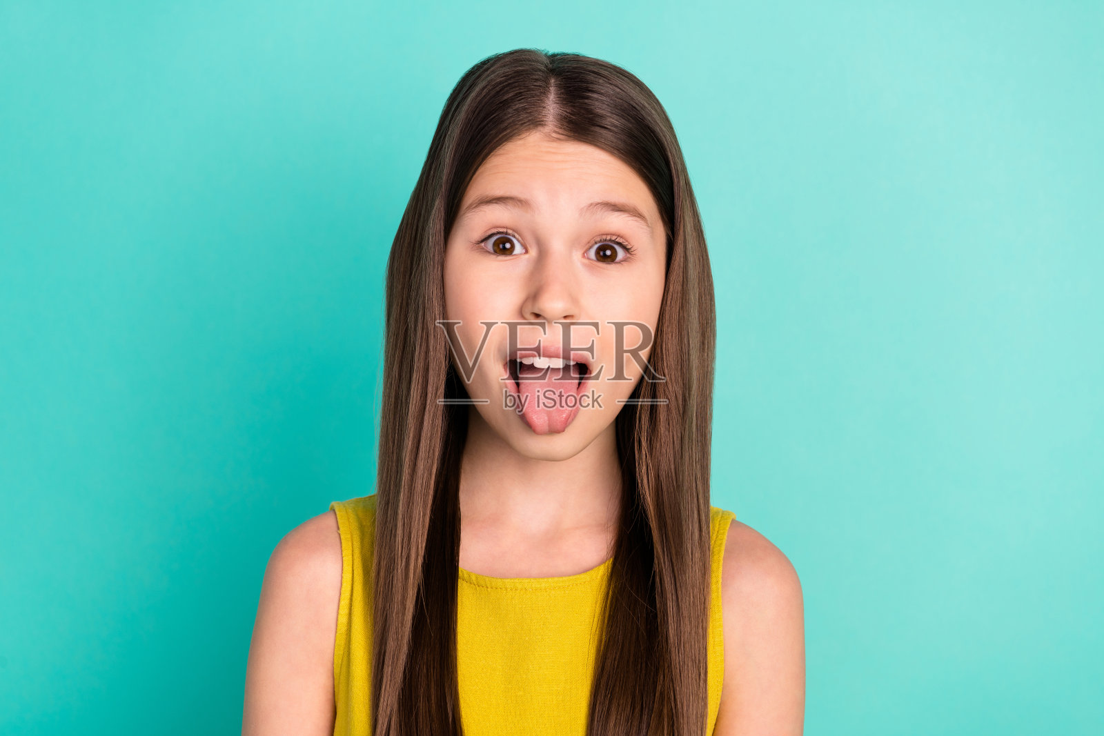 印象深刻的照片漂亮的棕色头发女孩穿黄色连衣裙孤立在明亮的蓝绿色背景照片摄影图片