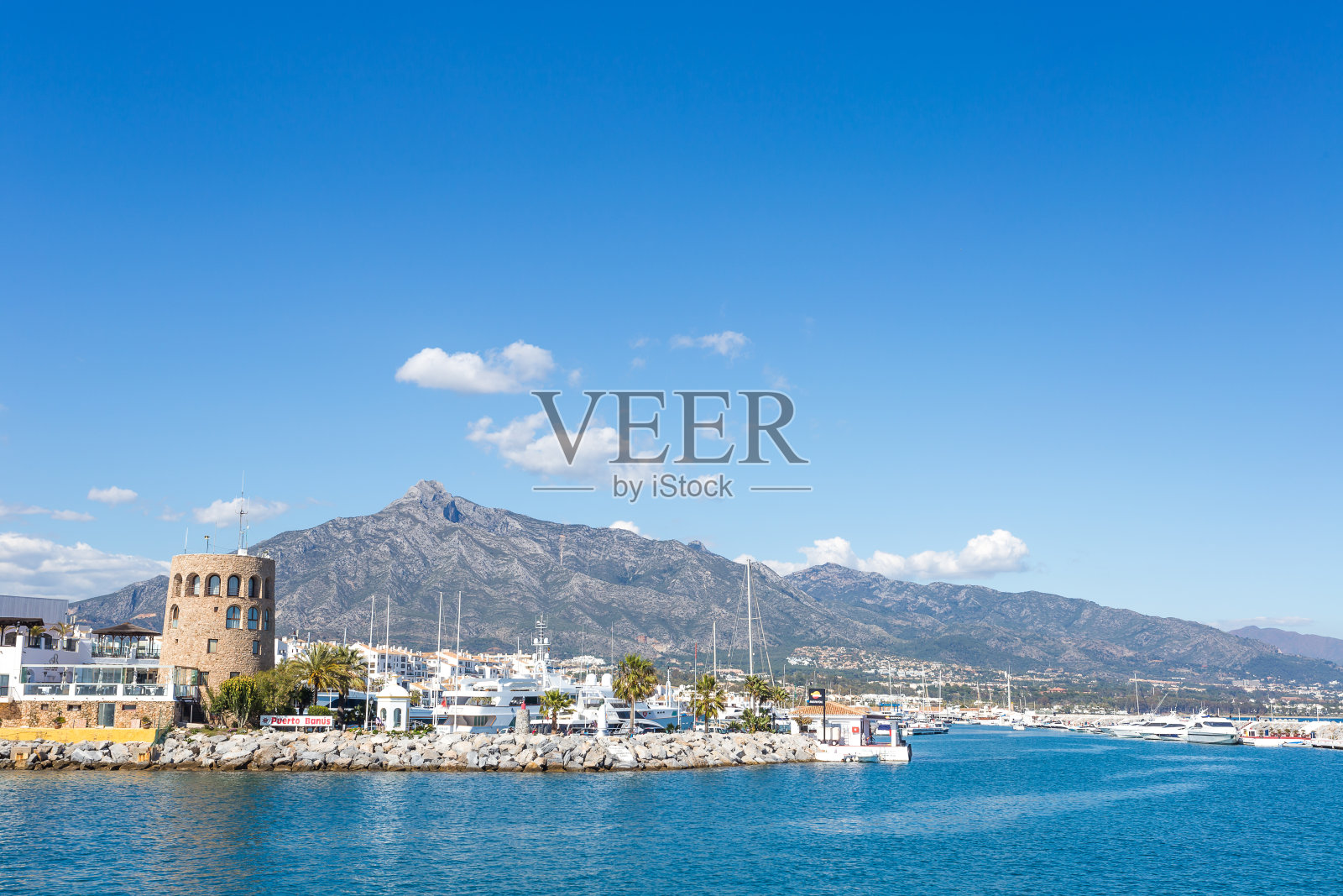 日出时分，西班牙安达卢西亚的马贝拉镇，巴努斯港码头上的船只和白色房屋照片摄影图片