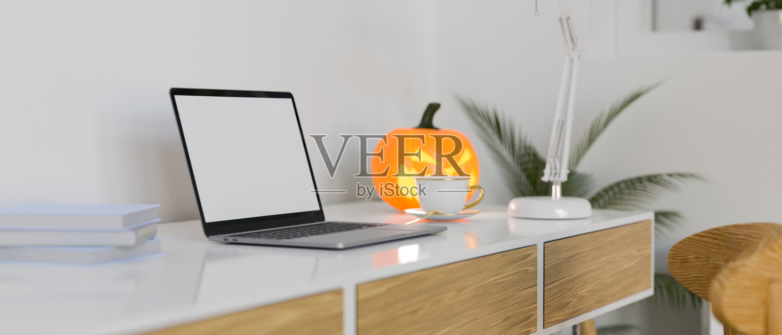 侧视图的现代工作空间与笔记本电脑，用品和万圣节装饰照片摄影图片