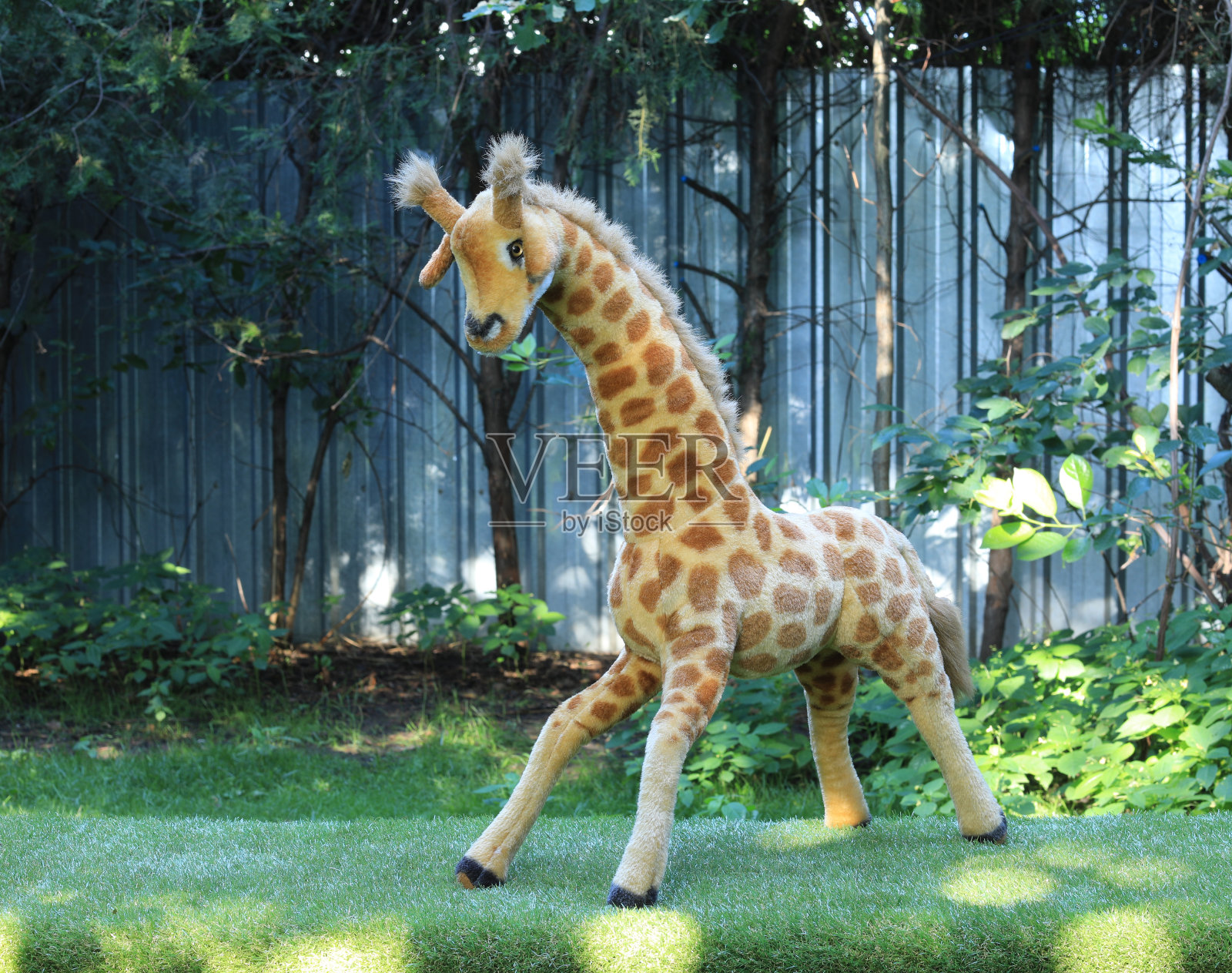 草地上的毛绒长颈鹿玩具照片摄影图片