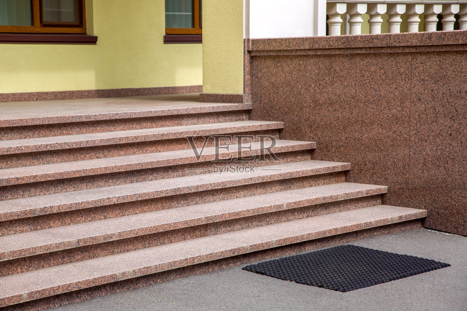 建筑外立面有花岗岩台阶，靠近门廊有窗户和栏杆的近景建筑，无人居住。照片摄影图片