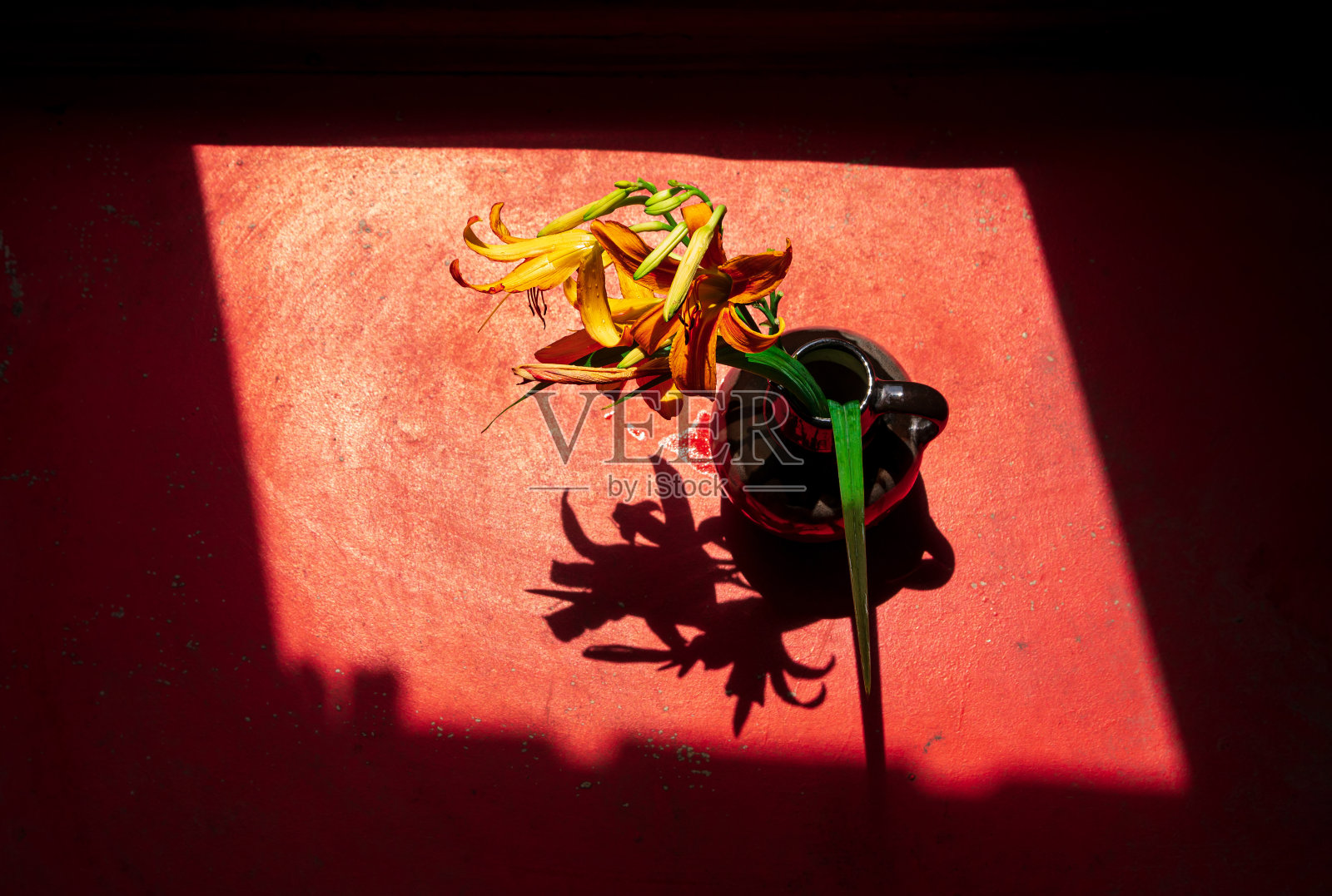 虎莲在陶瓷花瓶与粗糙的阴影在老房子。百合花花束木窗在阳光明媚的日子照片摄影图片