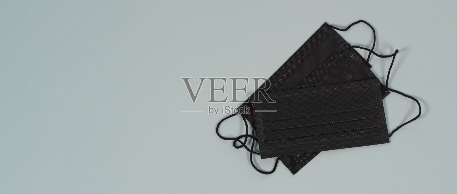 灰色背景上的黑色面罩。预防covid-19、流感和其他空气传播感染。本空间照片摄影图片