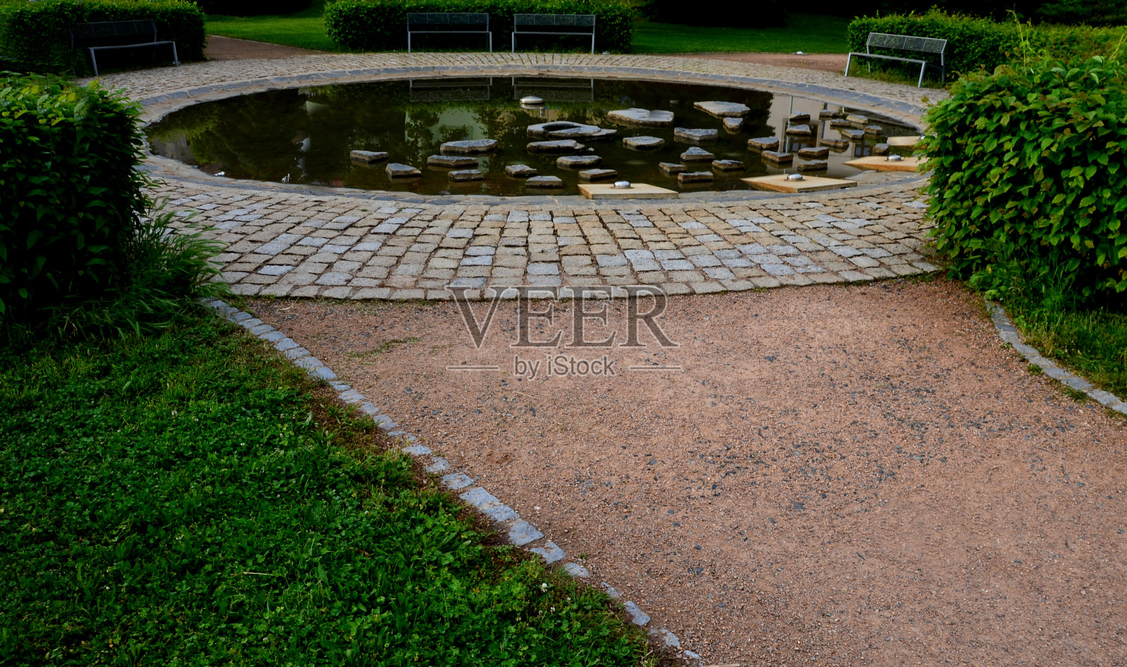 有喷水装置的圆形喷泉。海滨平缓，夏季适合儿童作为嬉水池。它们能跳过不规则的石头。地震火山口充满了水。公园照片摄影图片