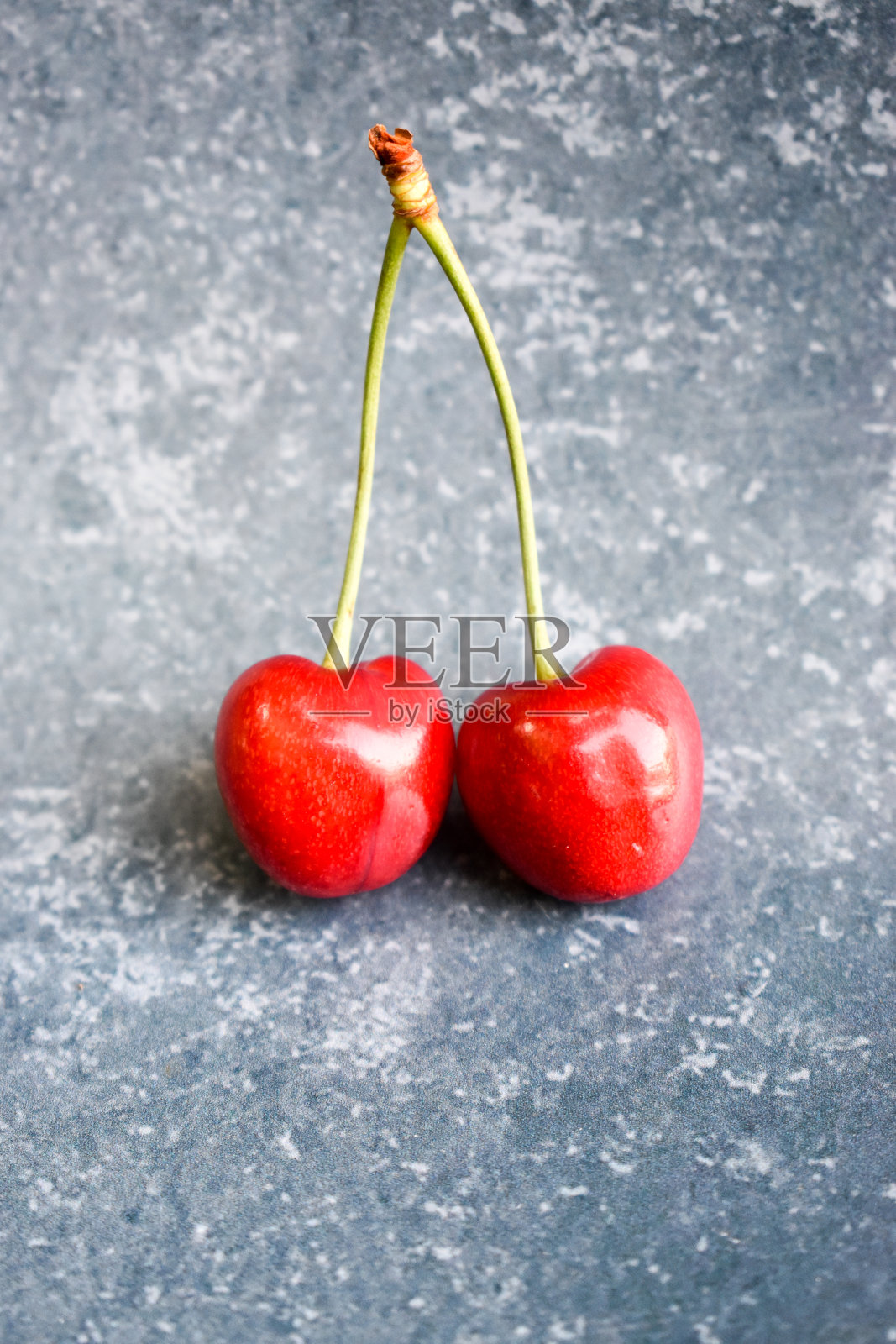 蓝色背景上的樱桃照片摄影图片