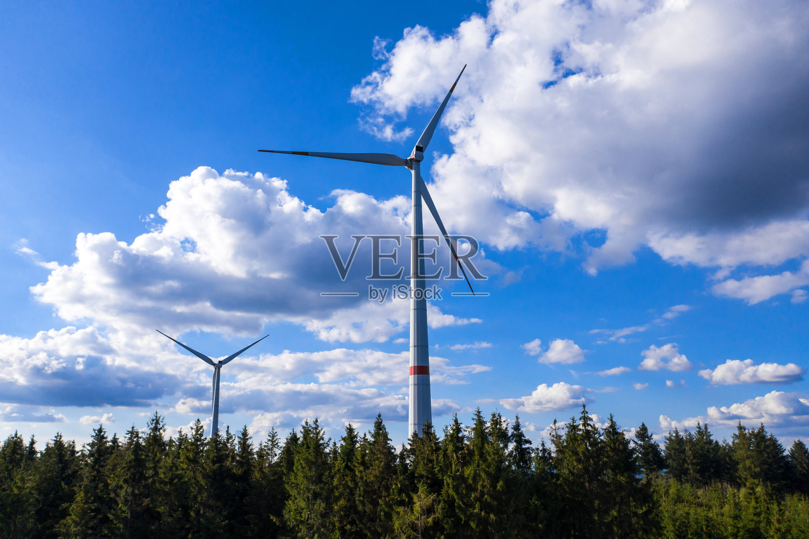 现代的风力涡轮机在蓝天和多云的天空前照片摄影图片