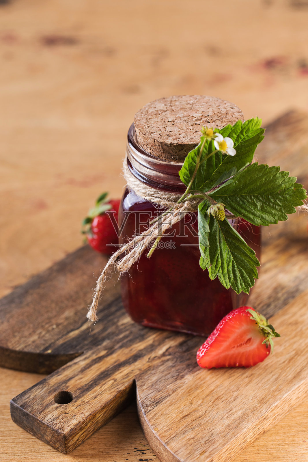 草莓酱装在罐子里，放在木板上。发酵的浆果。照片摄影图片