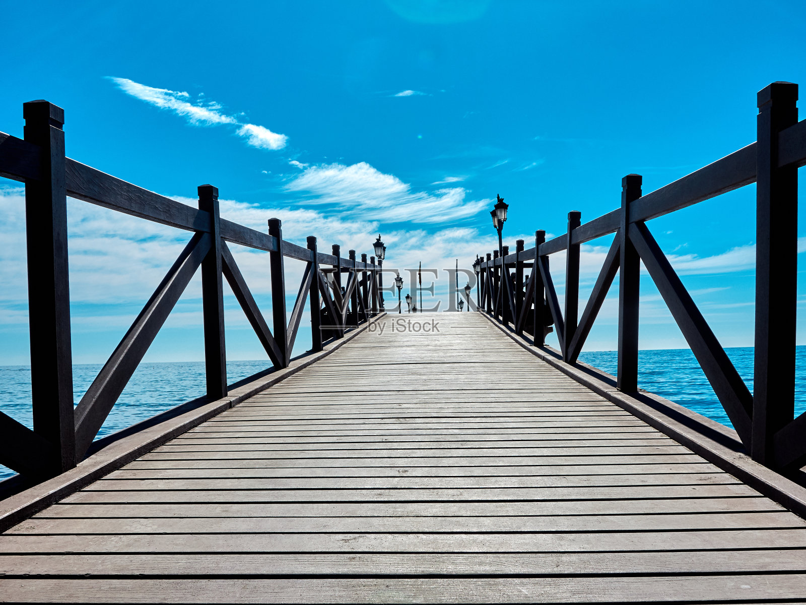 西班牙马尔贝拉太阳海岸的沙滩和木制码头照片摄影图片