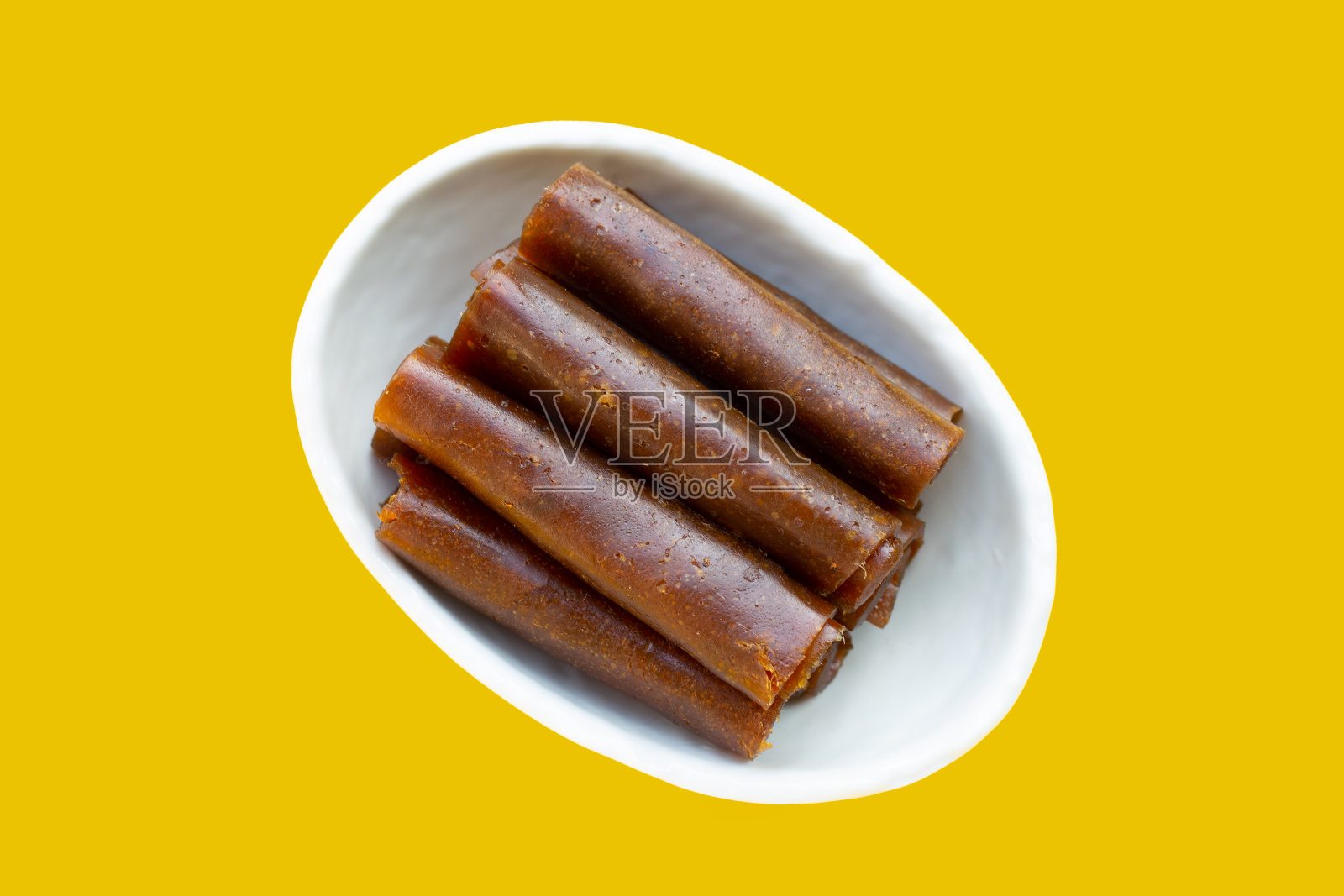 干芒果酱在白色碗黄色的背景。照片摄影图片