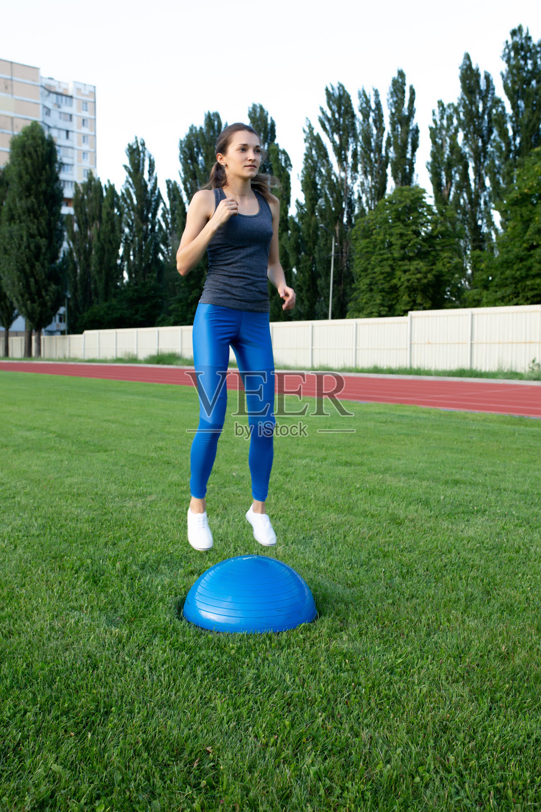 漂亮的女运动员在体育场用博苏球训练照片摄影图片