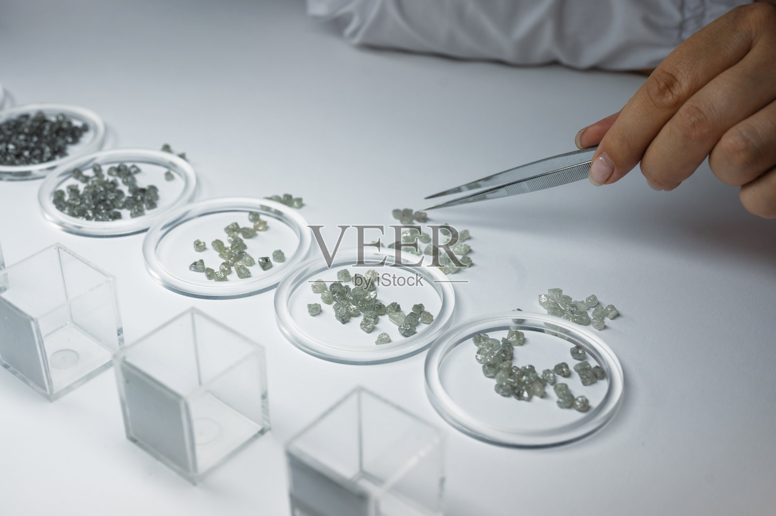 人工挑选钻石的过程。宝石按质量和重量分级照片摄影图片