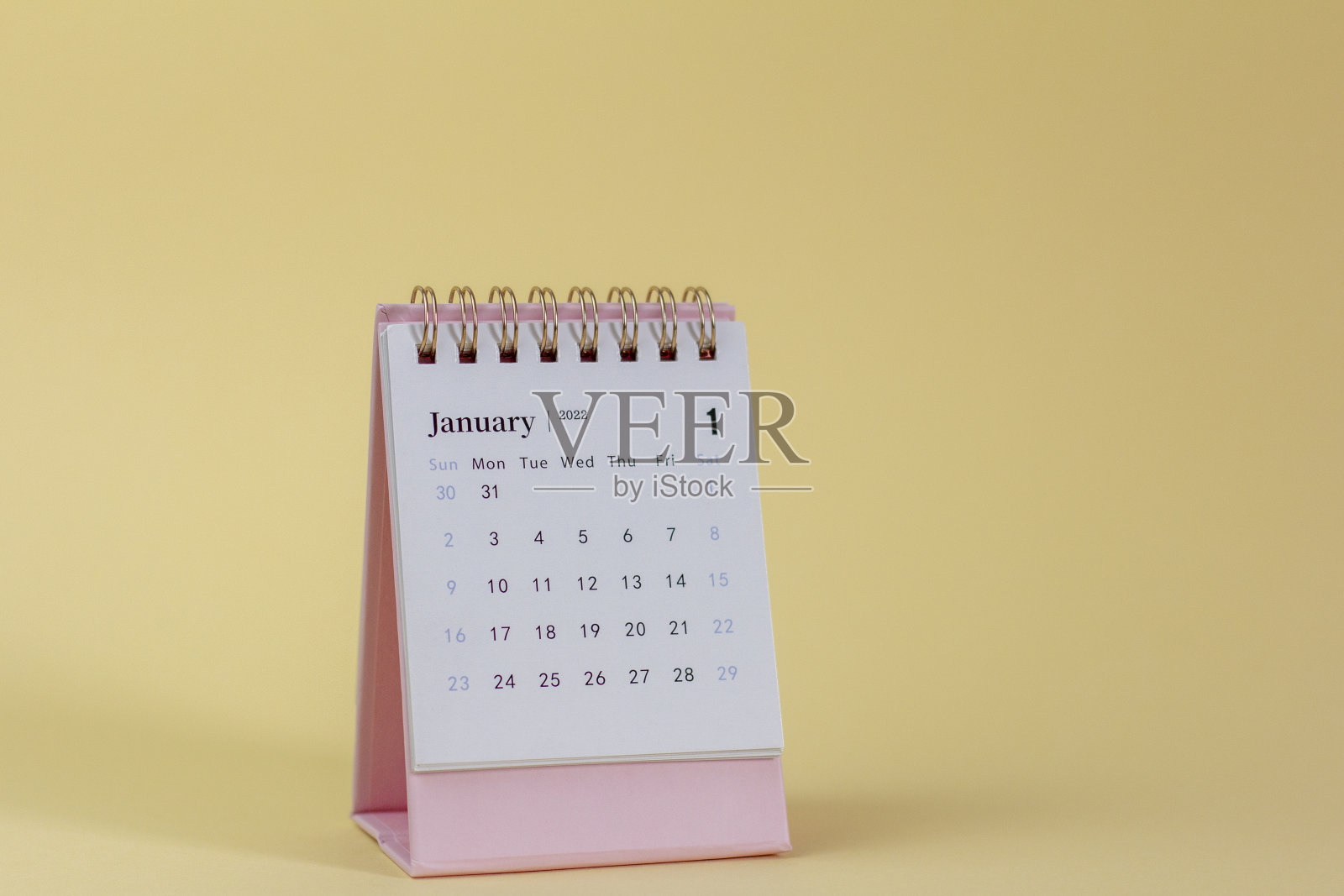 2022年1月的日历。桌面日历上的黄色背景。你好,2022。照片摄影图片