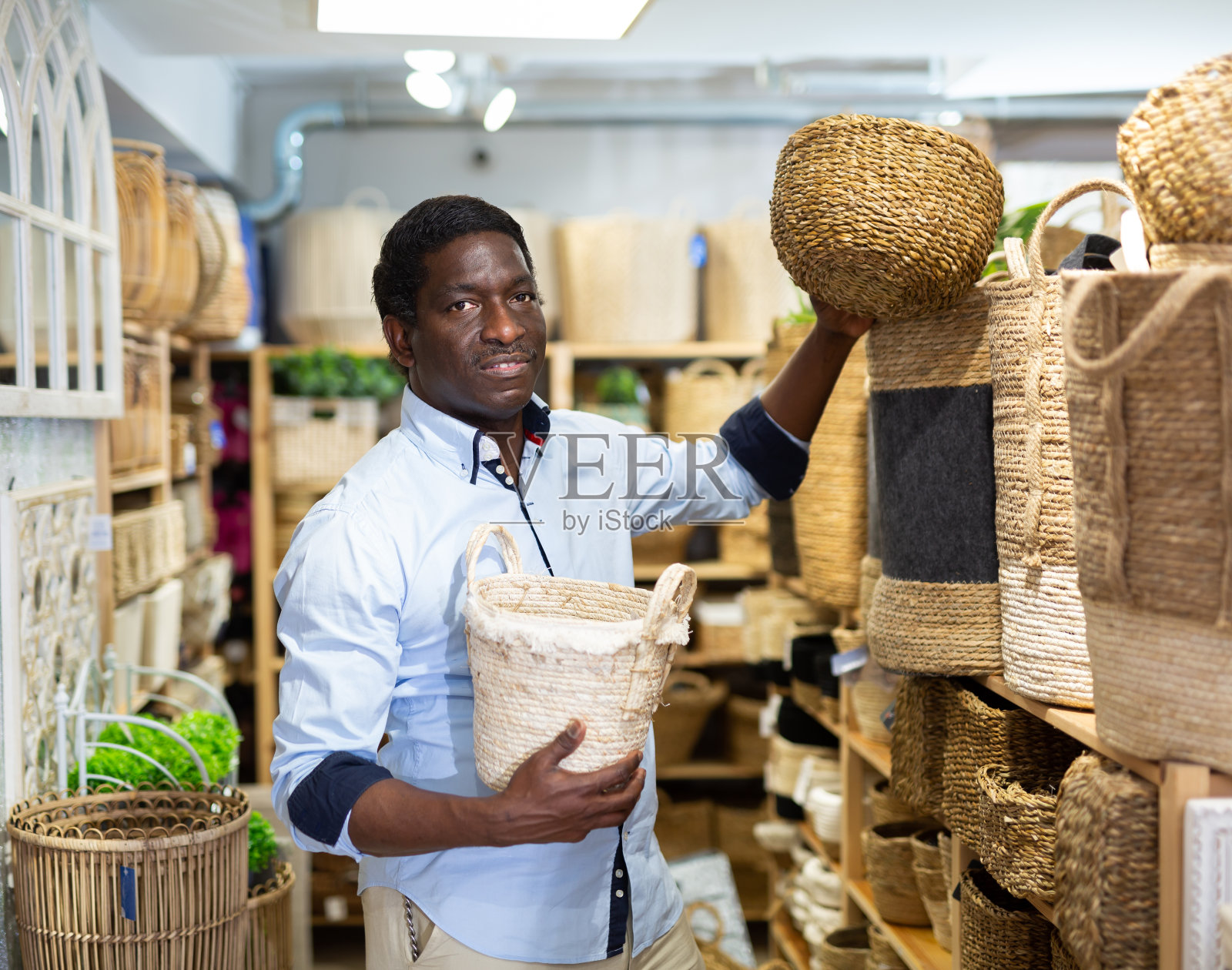 男人在五金店挑选柳条篮子照片摄影图片