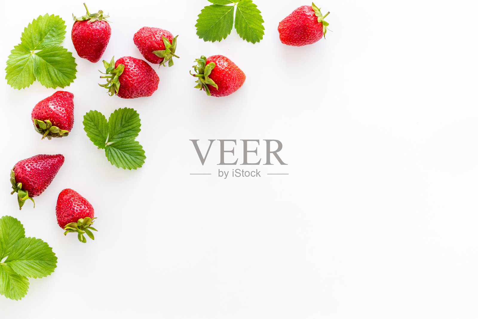 一组带绿叶的成熟草莓。平躺照片摄影图片