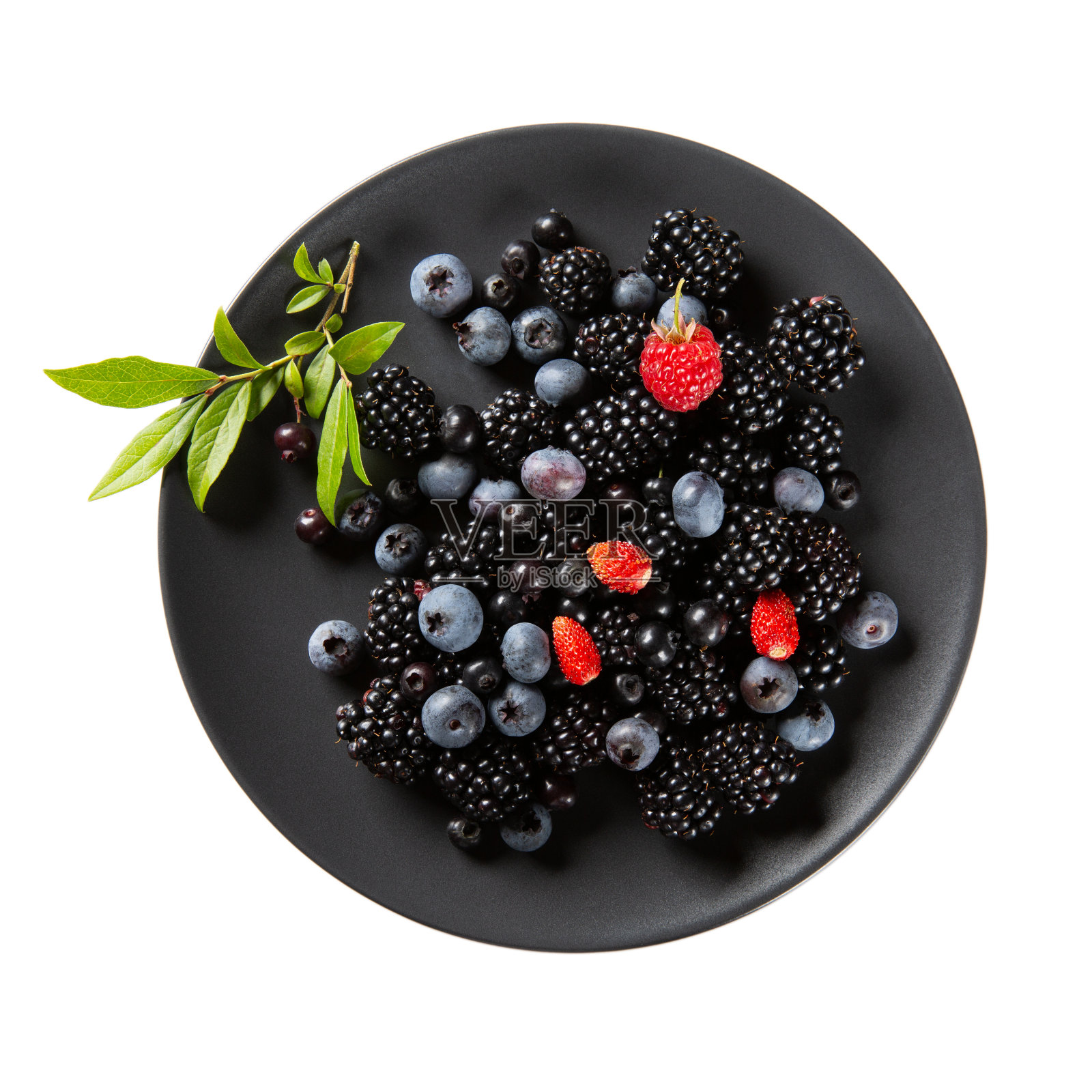 成熟的浆果放在黑色的盘子上，孤立在白色的盘子上。黑莓、蓝莓、红野草莓和覆盆子。顶视图,特写。照片摄影图片