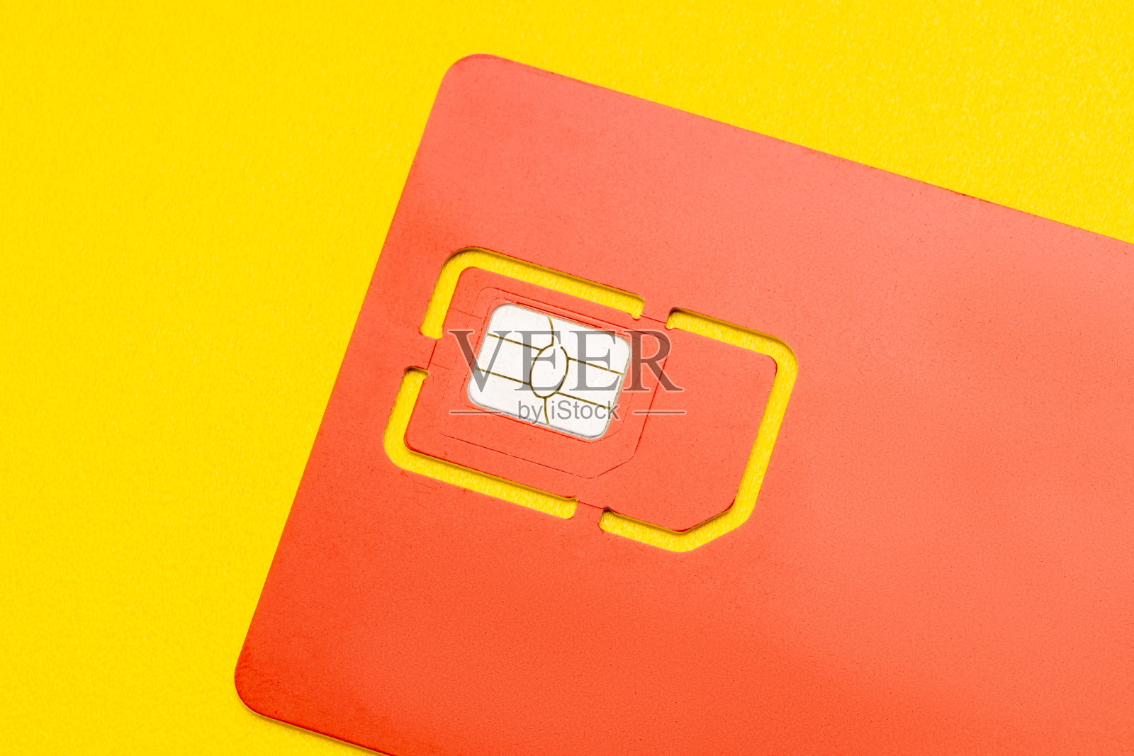 手机Sim卡隔离黄色背景。智能手机的4G sim卡被删除了照片摄影图片