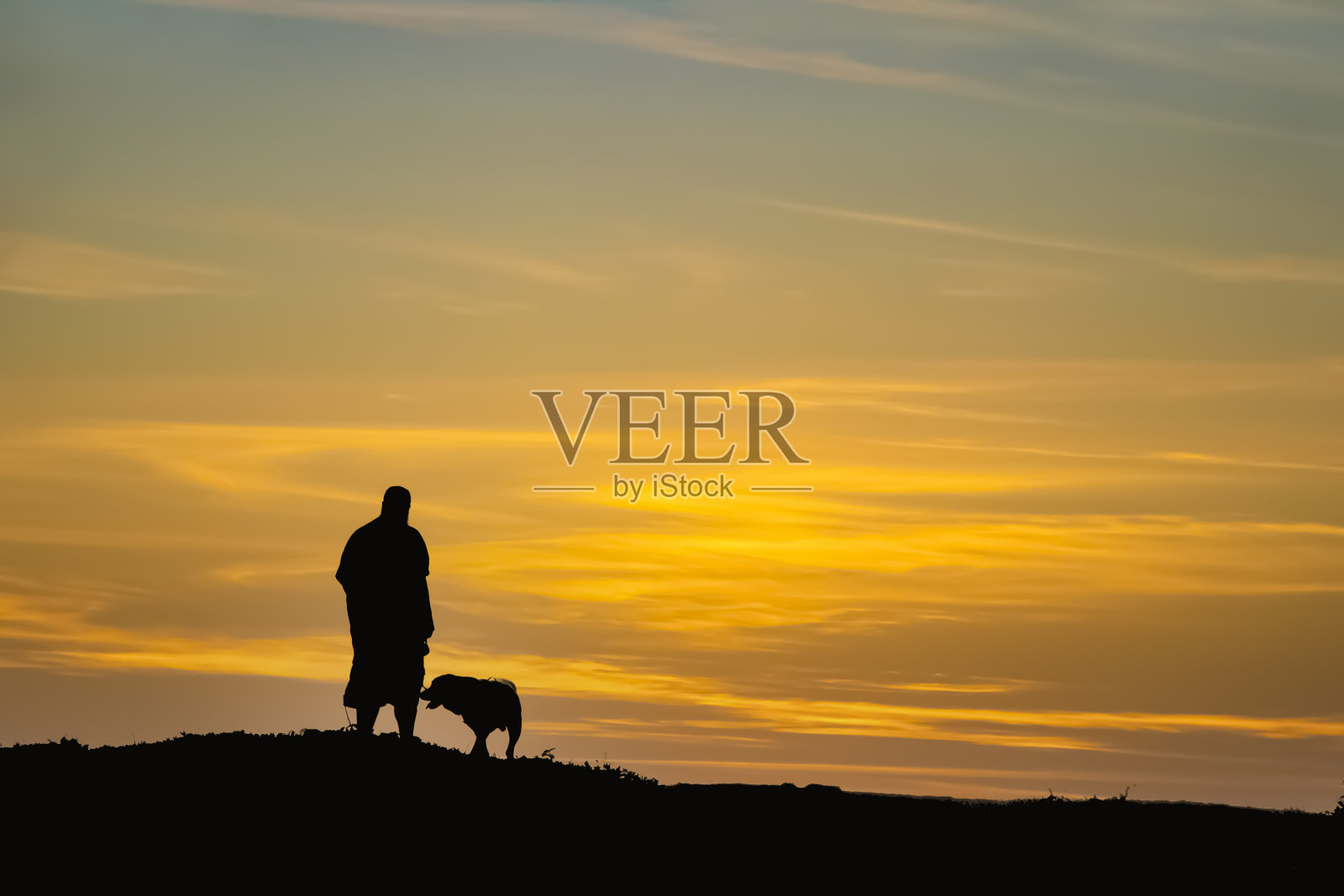 黑色和白色的剪影的人和他的狗在山顶日落-房间的文本副本照片摄影图片