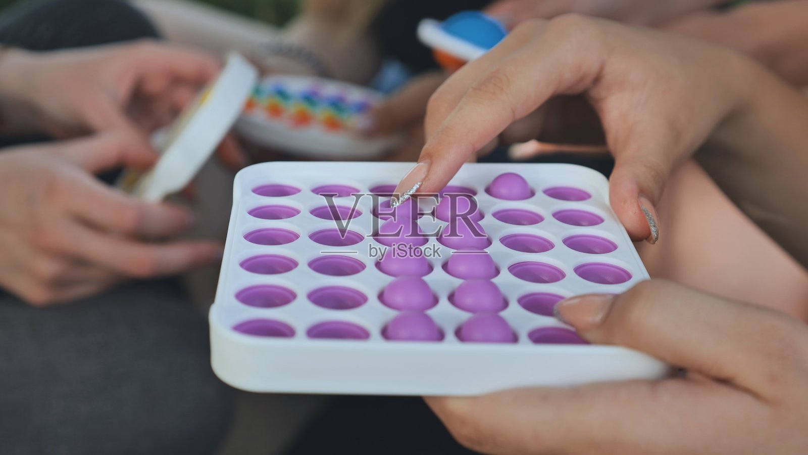 女孩玩简单的酒窝放松玩具和爆它照片摄影图片