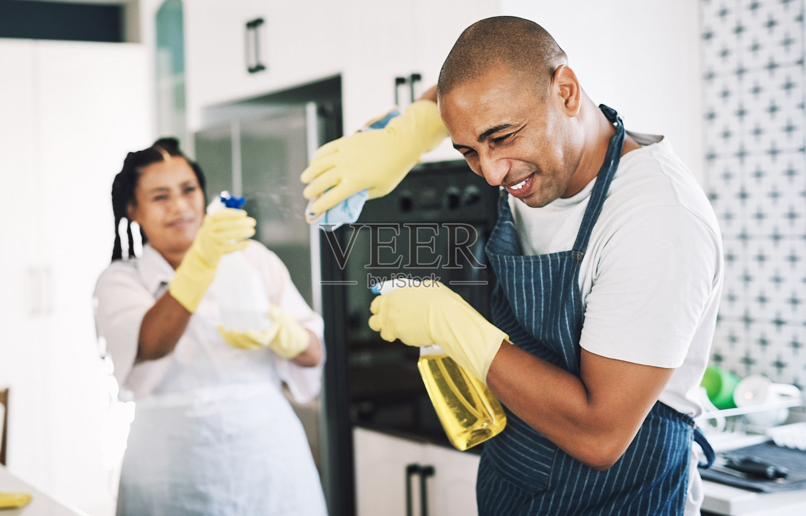 这是一对年轻夫妇在打扫房间时嬉戏的照片照片摄影图片