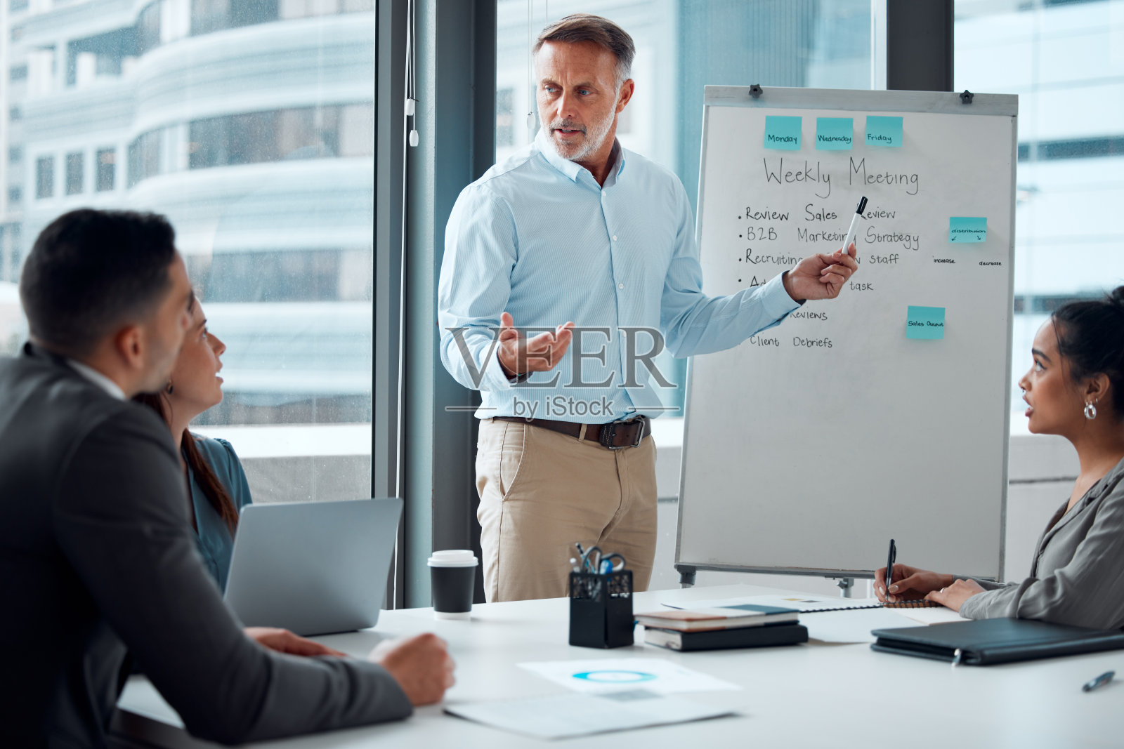 一个成熟的商人在办公室给同事做演示的照片照片摄影图片