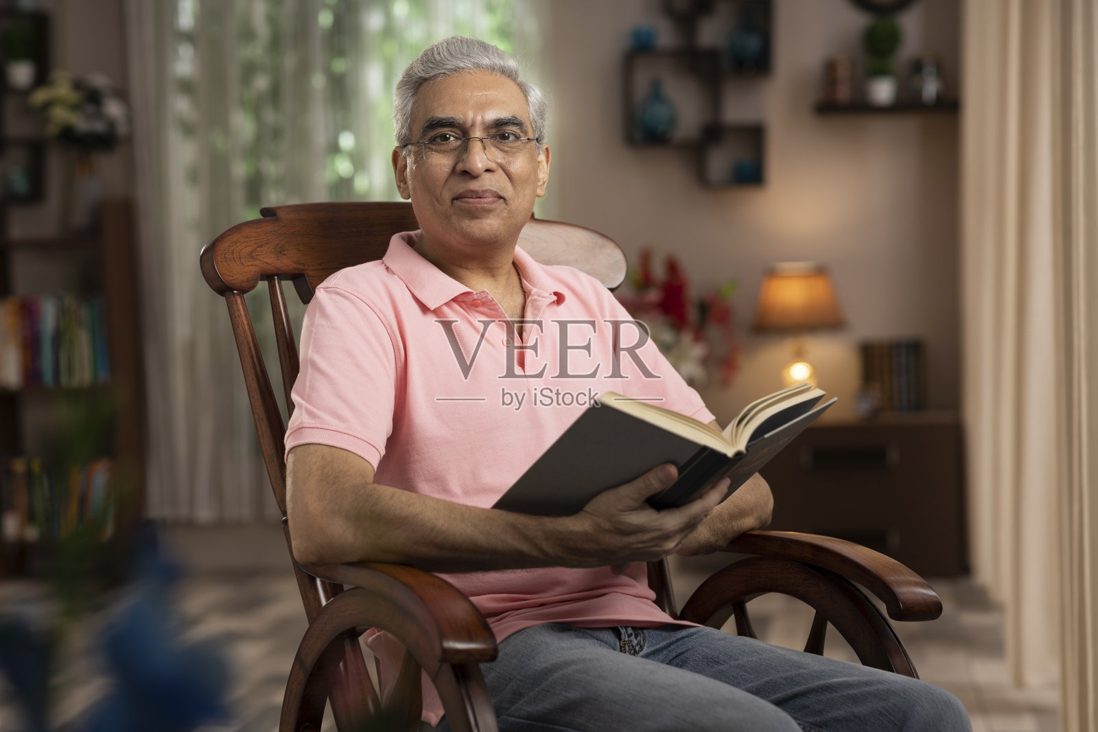 一个成年人坐在家里的摇椅上的照片:-库存照片照片摄影图片