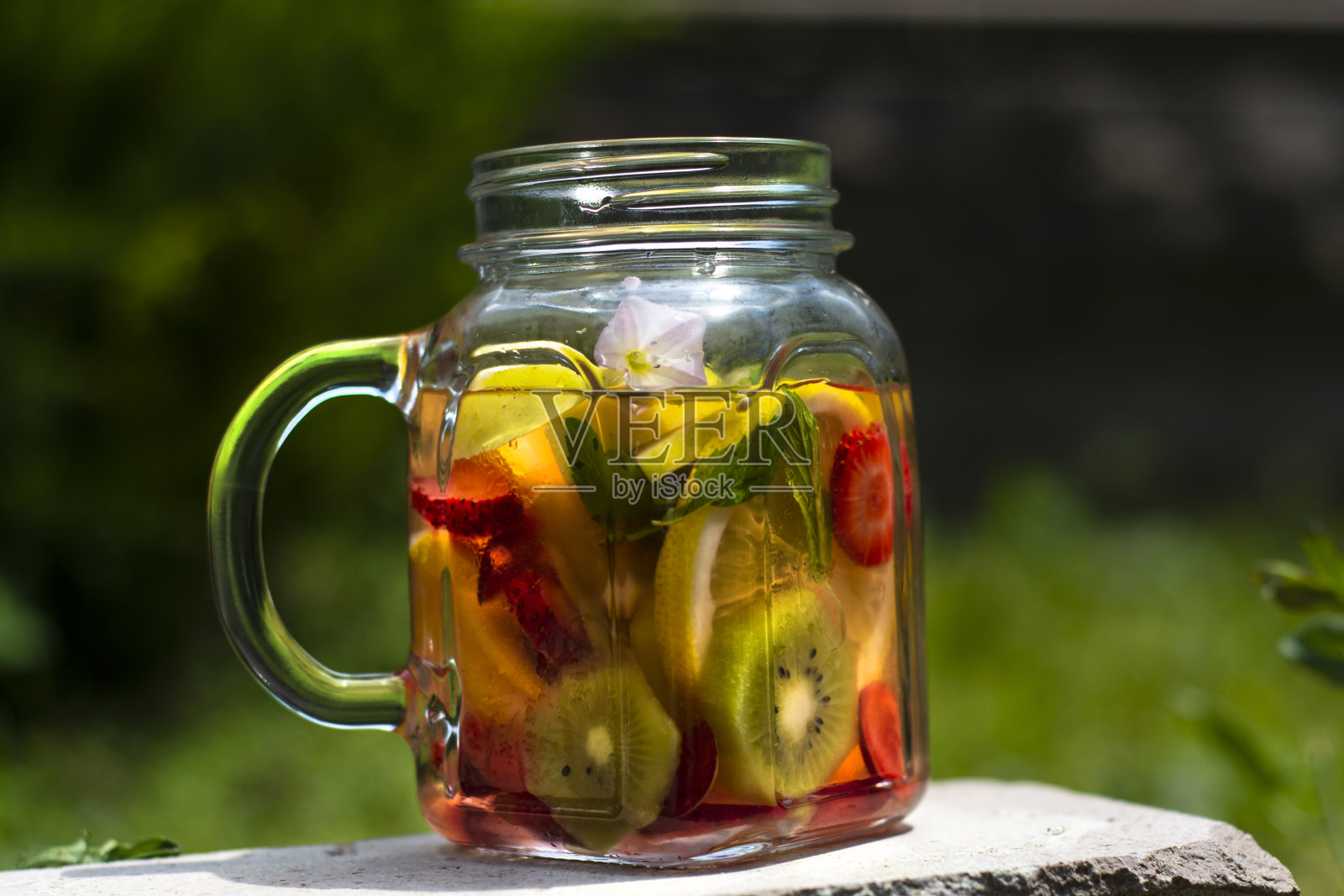 美味的排毒饮品，搭配红色、橙色和黄色的水果，照片摄影图片