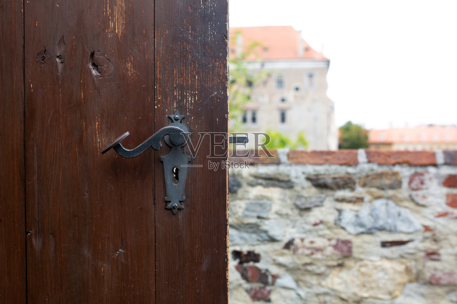 老式划痕门把手的棕色木门对抗城市全景照片摄影图片