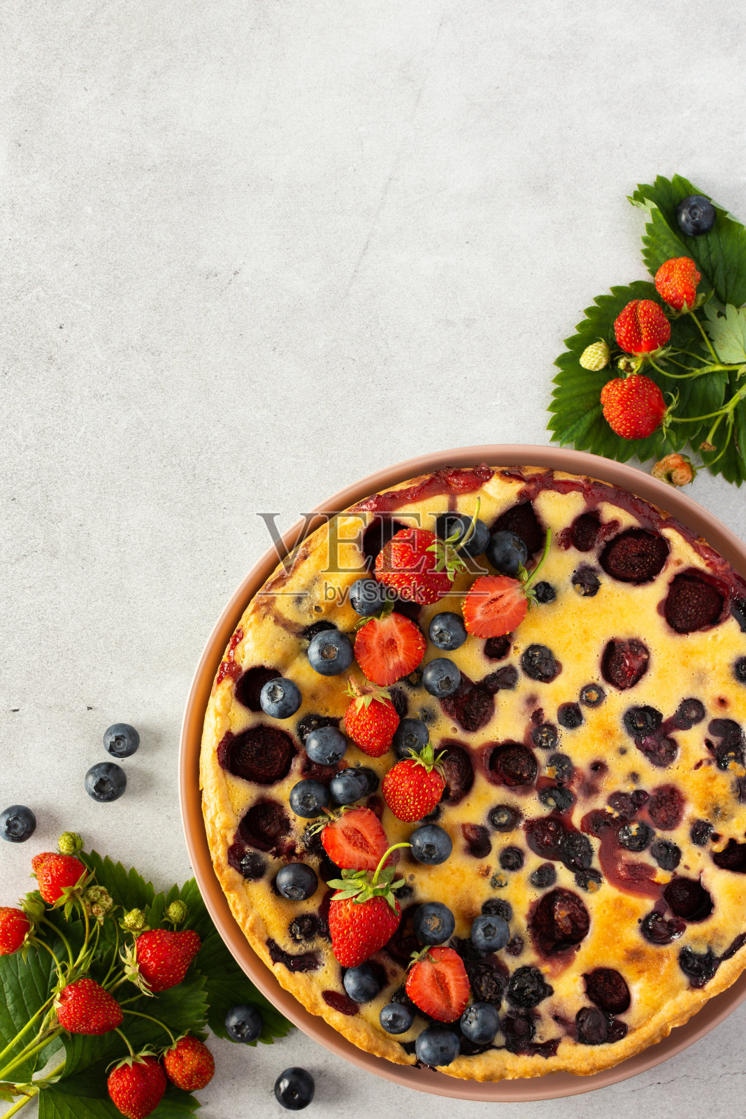 用新鲜浆果装饰的草莓蓝莓派照片摄影图片