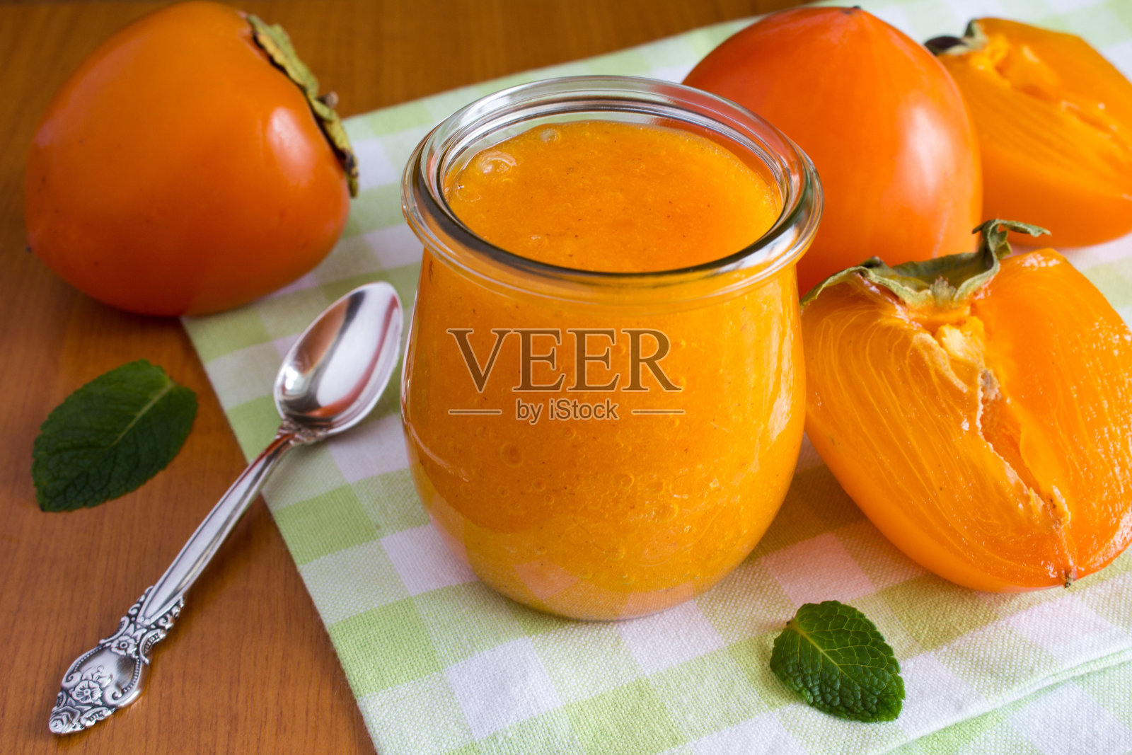 绿色餐巾上的玻璃罐里有柿子酱照片摄影图片