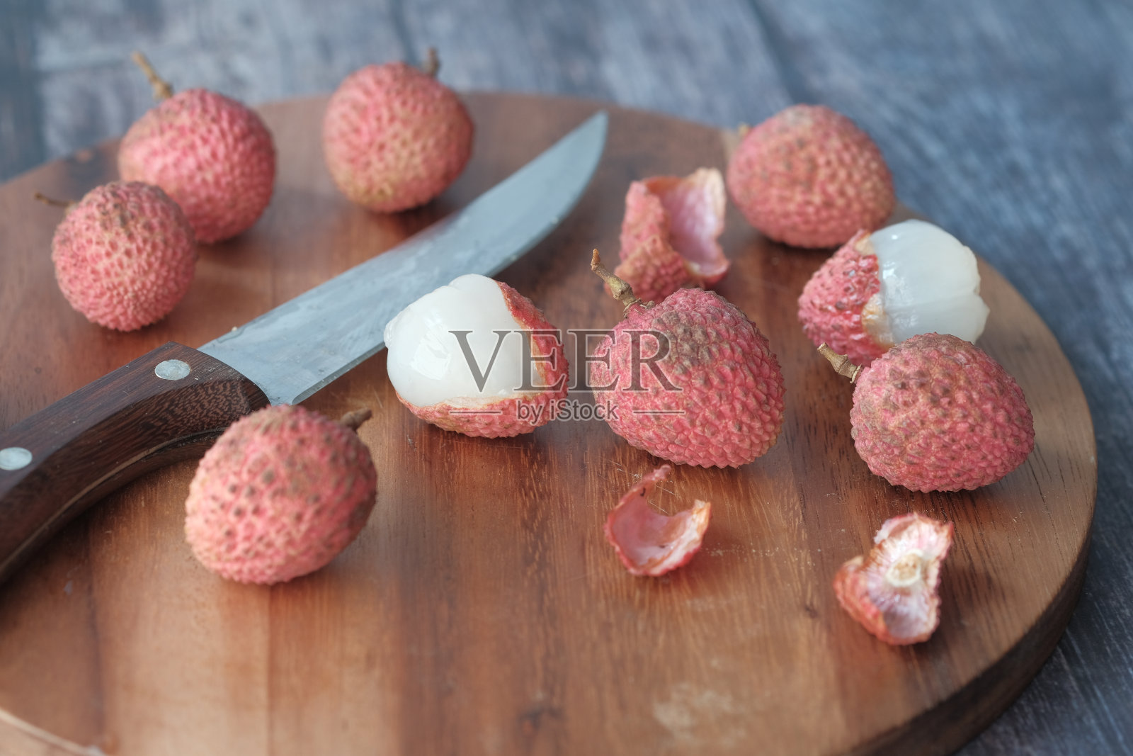 桌上的切菜板上放着荔枝照片摄影图片