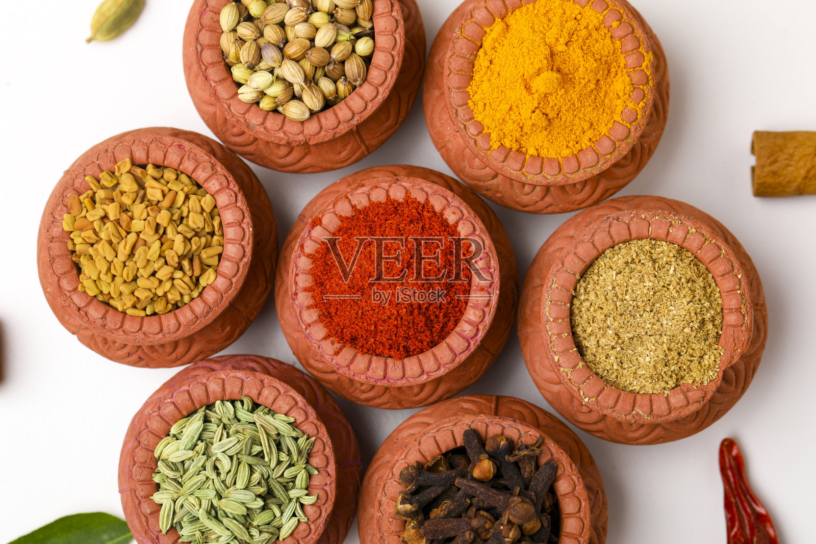 印度香料收集，干燥的彩色调味品，坚果，豆荚和种子和其他香料在粘土碗。照片摄影图片