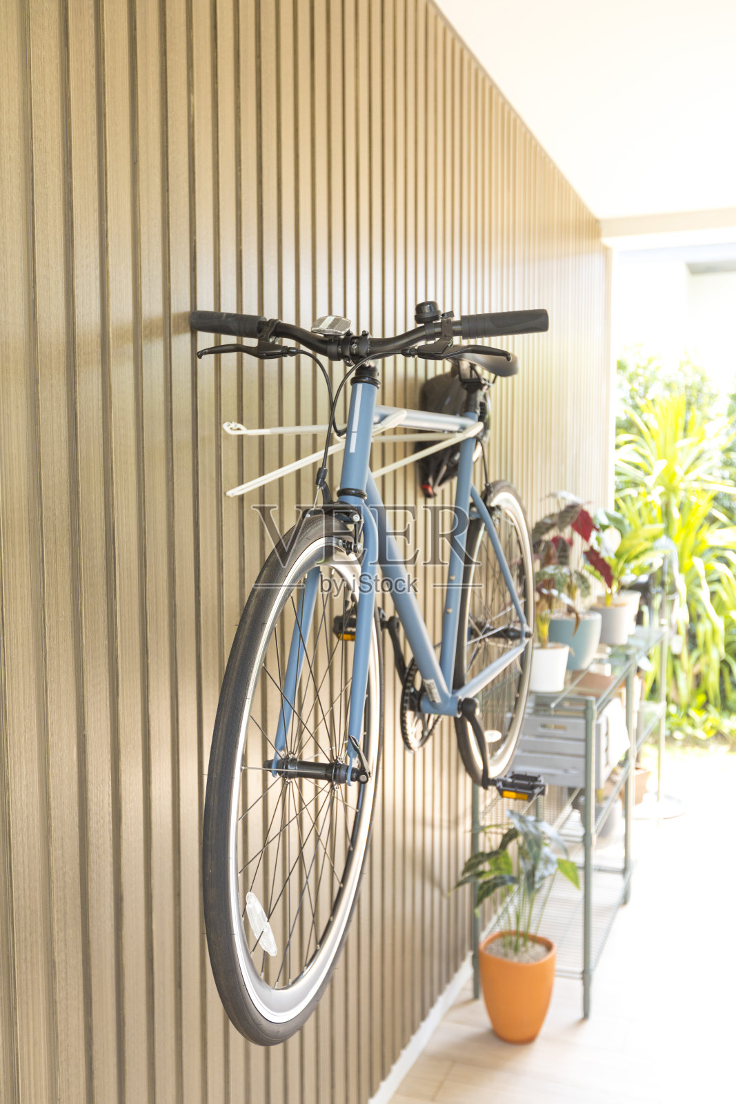 自行车挂在房子的木墙上。照片摄影图片