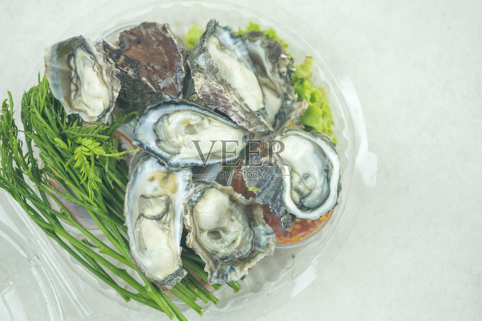 盒装新鲜牡蛎配香草和辣酱。每一种成分都是分开准备的，以便混合食用。照片摄影图片