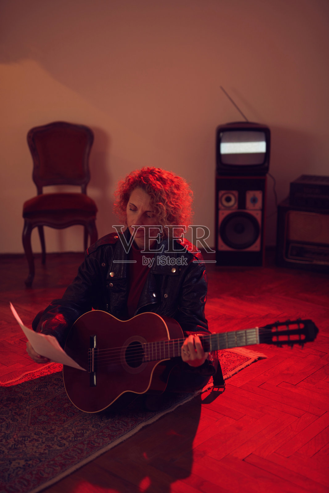 一个在复古房间里弹原声吉他的女人。照片摄影图片