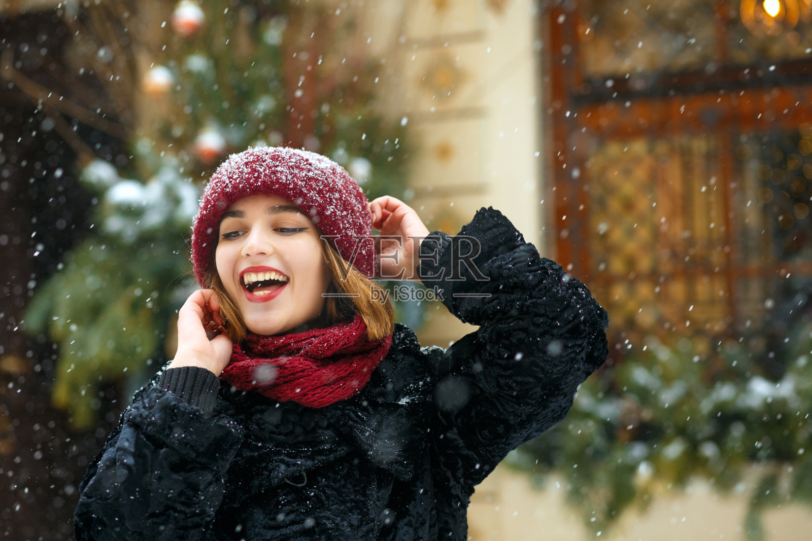 戴着针织帽享受降雪的酷女孩照片摄影图片