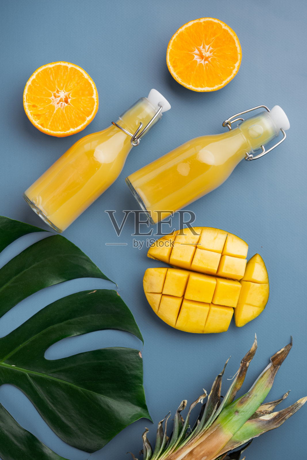 成熟多汁的新鲜热带水果，在蓝色纹理的夏季背景，俯视图平坦lay照片摄影图片