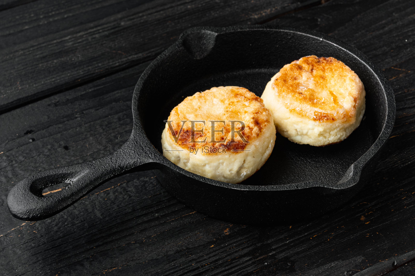 奶酪煎饼放在铸铁煎锅上，放在铸铁煎锅上，放在旧的深色木桌上照片摄影图片