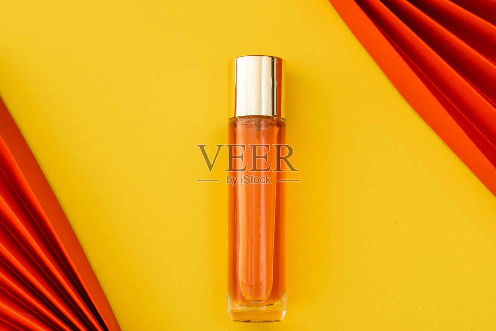 黄色背景上的粉色香水与红色纸上的折纸元素照片摄影图片