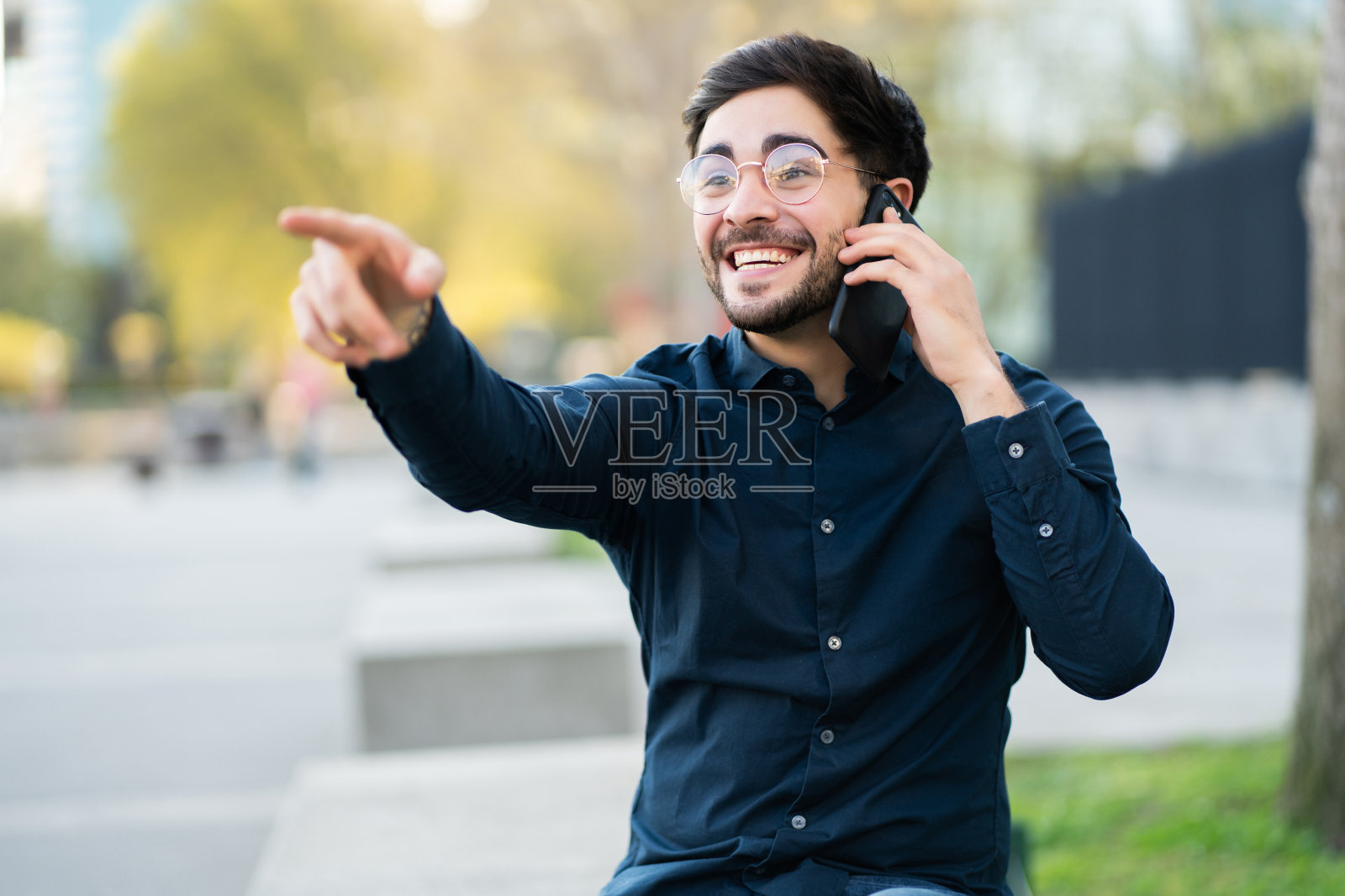 一个年轻人在外面打电话。照片摄影图片