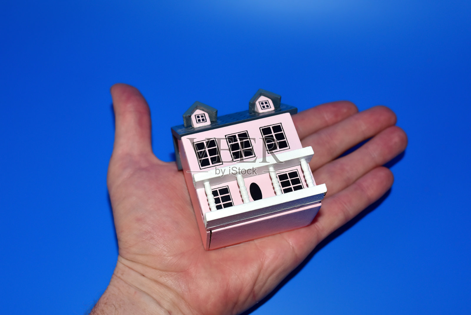 蓝色背景上的微型房子。房屋买卖。家的家庭。照片摄影图片