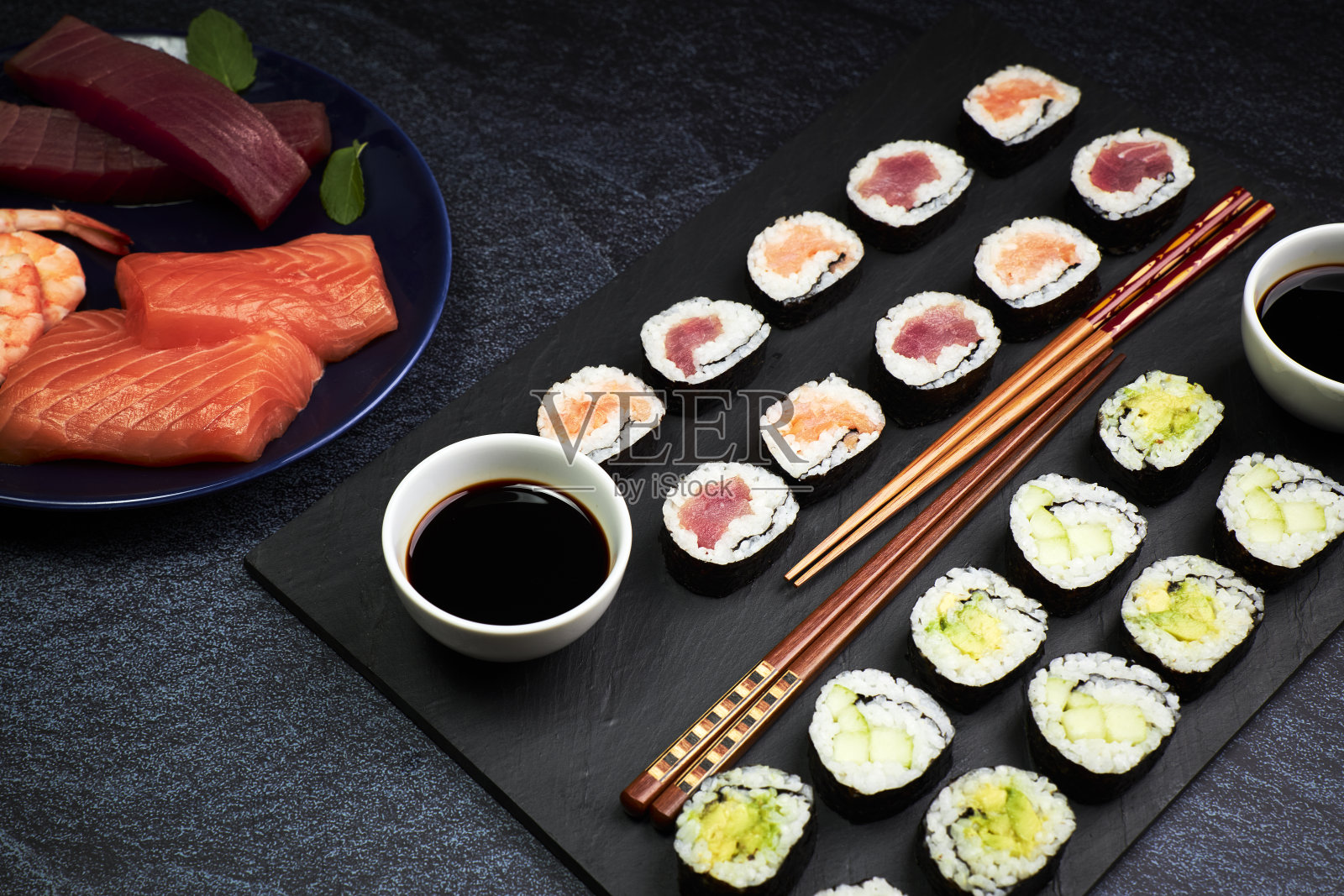 提供鱼寿司和蔬菜寿司用筷子和一个盘子与配料。东方的食物。日本文化照片摄影图片