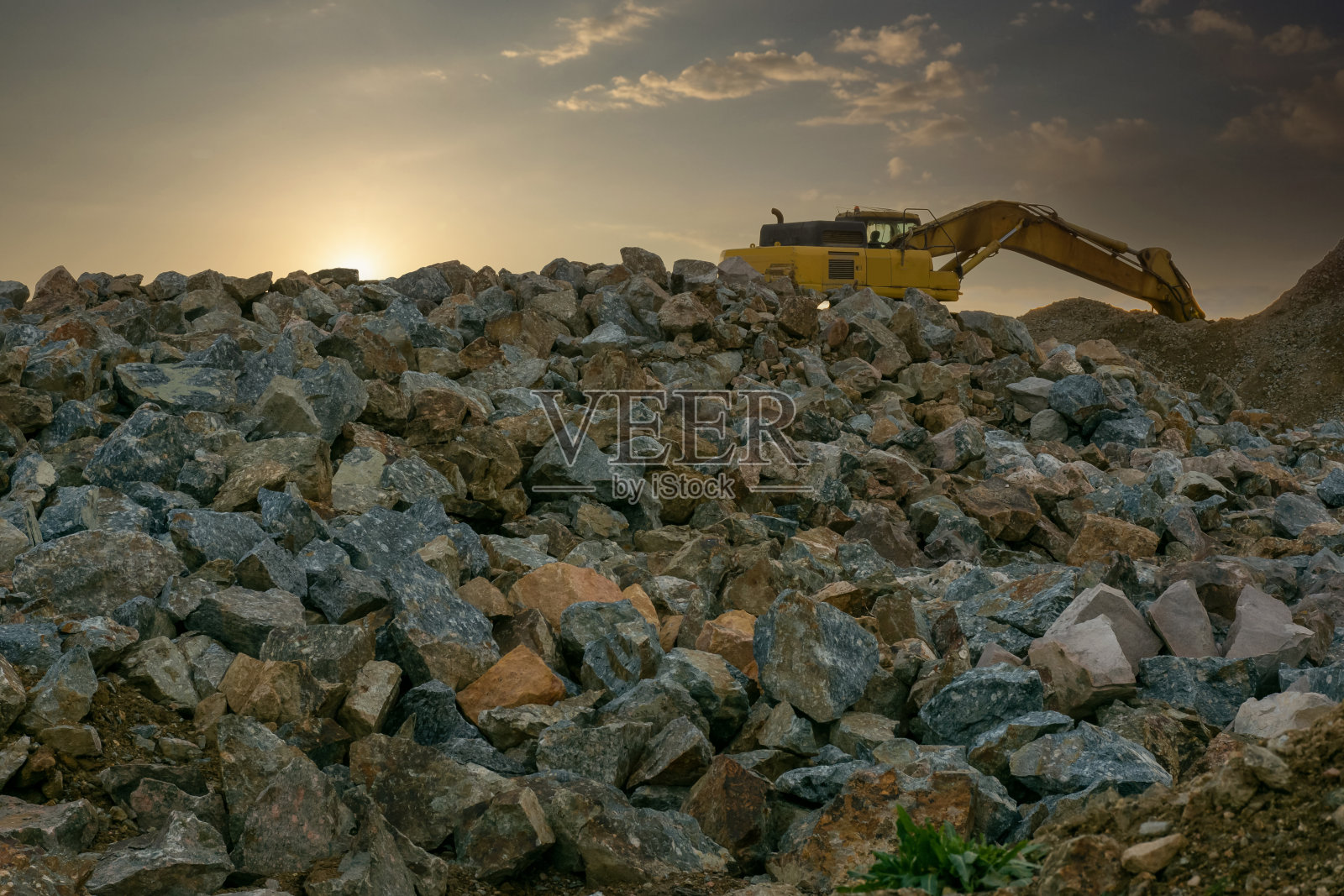 挖掘机在采石场周围的岩石转化成砾石照片摄影图片