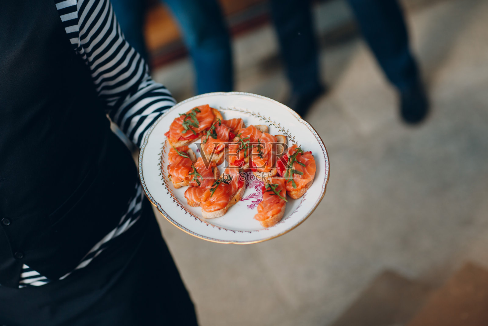 食品配餐时，开胃菜、小吃放在服务员手里的托盘上照片摄影图片