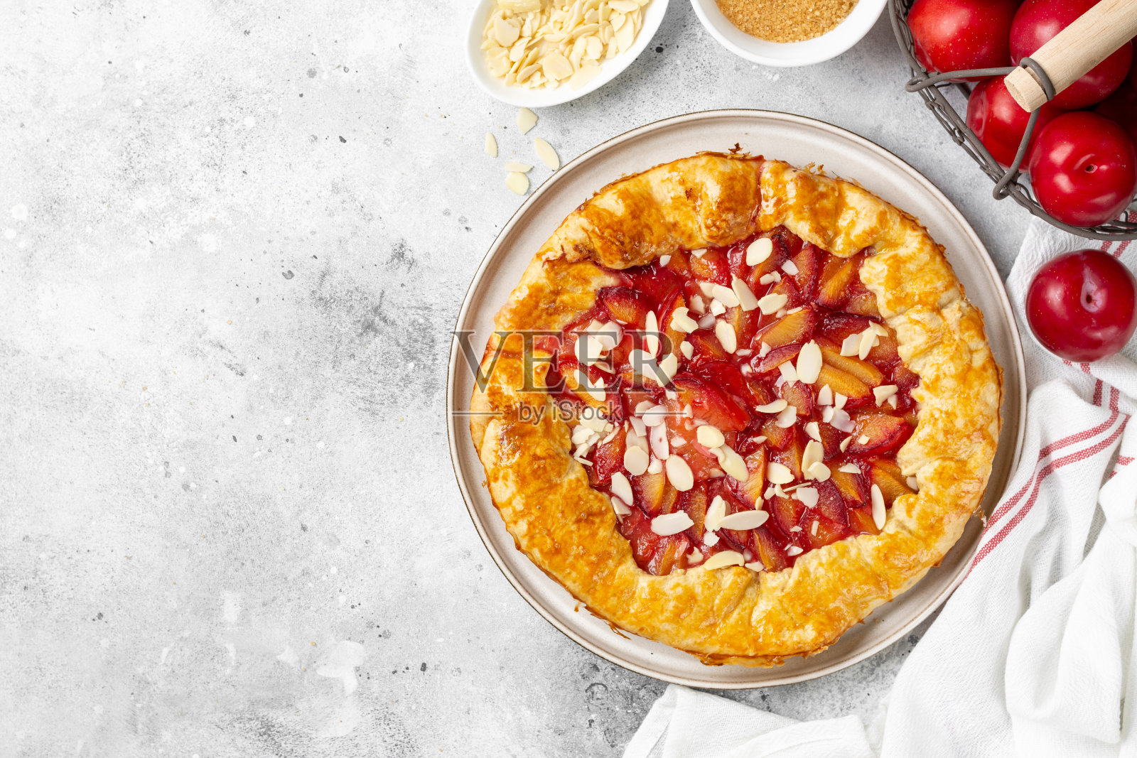 在明亮的厨房桌子上，用陶瓷盘子盛着法式葡萄干或杏仁派。夏日传统自制甜点照片摄影图片