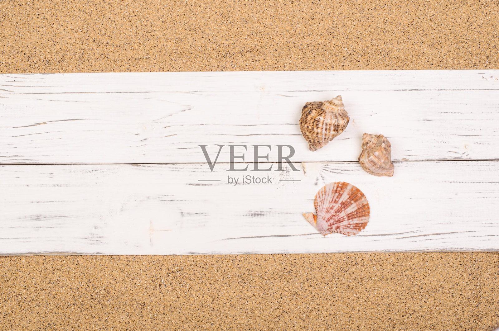 贝壳上的白木板上的沙，复制空间照片摄影图片