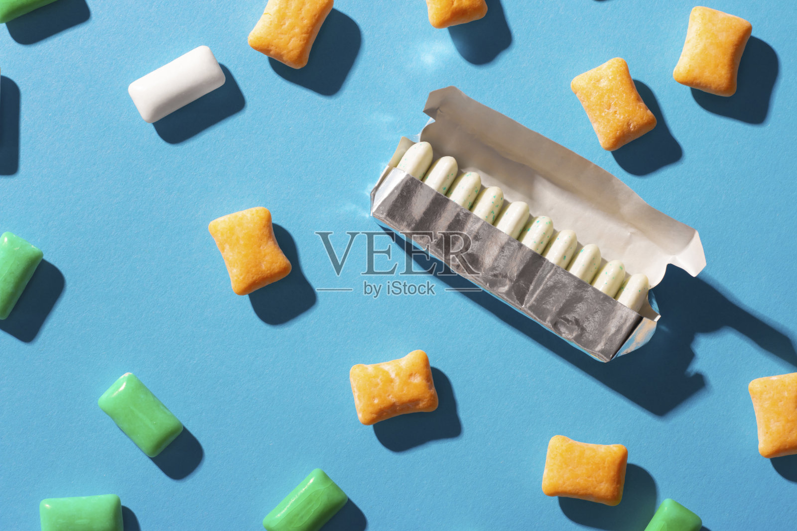 蓝色背景上的多色口香糖照片摄影图片
