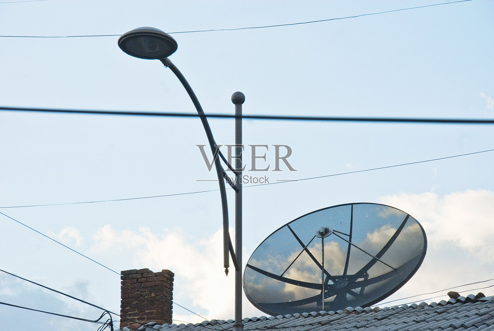 屋顶上与天空相对的卫星接收器照片摄影图片